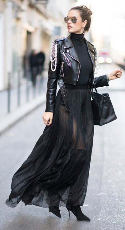 Total black outfit με κοντό δερμάτινο μπουφάν και μακριά πλισέ φούστα από διαφάνεια