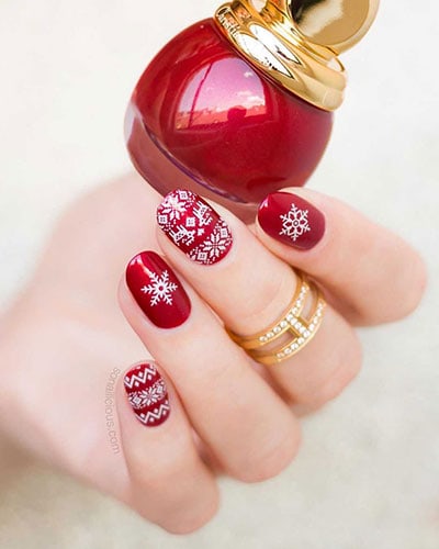Γιορτινά κόκκινα βαμμένα νύχια με λευκά σχέδια