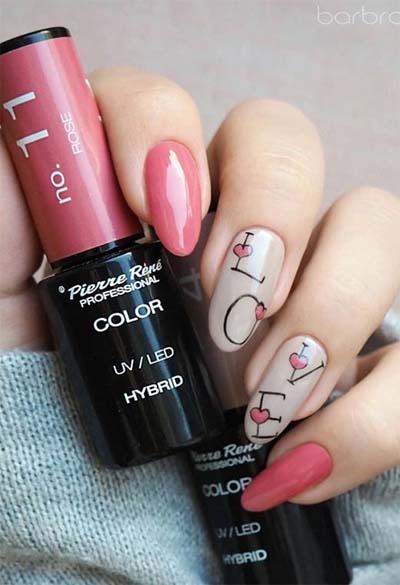 Ροζ νύχια με ζωγραφισμένη τη λέξη LOVE