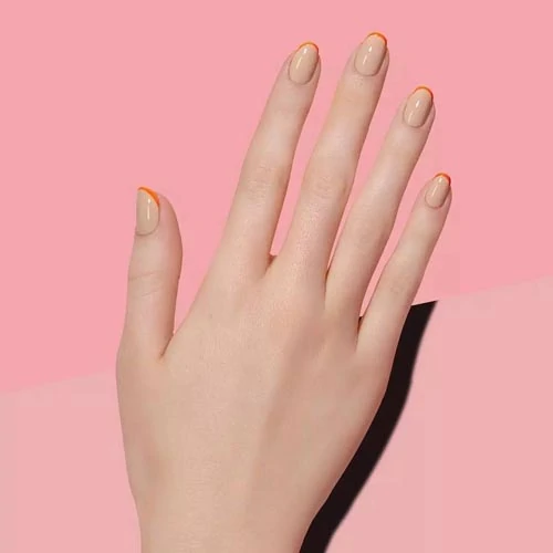 Οβάλ nude νύχια με λεπτή πορτοκαλί γραμμή γαλλικού