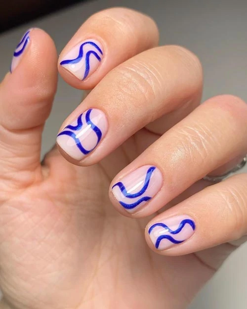 Nude νύχια με μπλε κυματιστές γραμμές