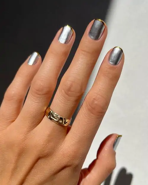 Ασημί νύχια με μεταλλικό βερνίκι και χρυσή γραμμή γαλλικού - Photo: @betina_goldstein